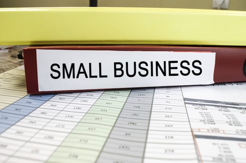 Close-up of a red folder with space for text that is located on documents with colored columns of numbers. Business and financial concept